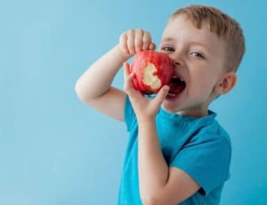 small boy eating an apple