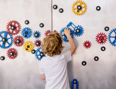 Child playing with gear wall at Cambridge Science Centre