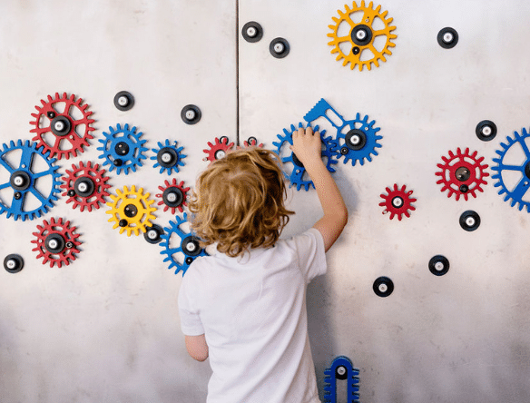 Child playing with gear wall at Cambridge Science Centre