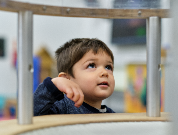 Toddler playing with wind tunnel as Science Centre