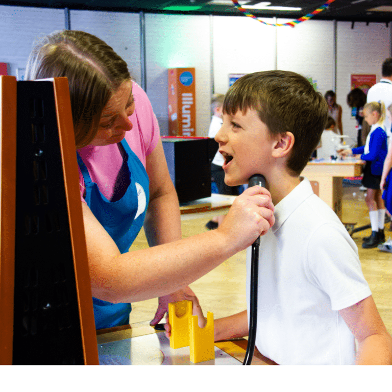 Science Communicator Helen demonstrates a vocal chord machine to a boy