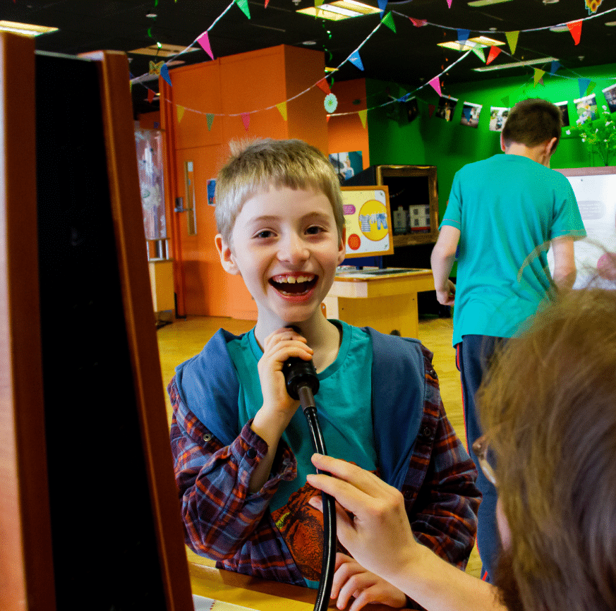 Smiling boy trying a vocal chord recognition exhibit